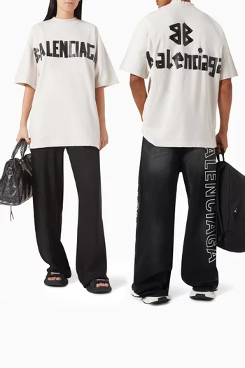 تي شيرت بقصة فضفاضة قليلاً وشعار الماركة بتصميم شريط جيرسيه باهت للجنسين